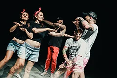 Trzy osoby w jednym rzędzie z lewą ręką uniesioną na wysokości brody rapują